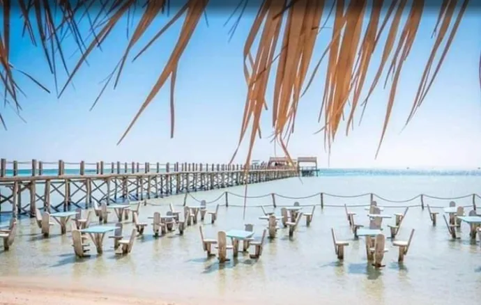 Ponton en bois menant à une plateforme sur l'eau tables et chaises