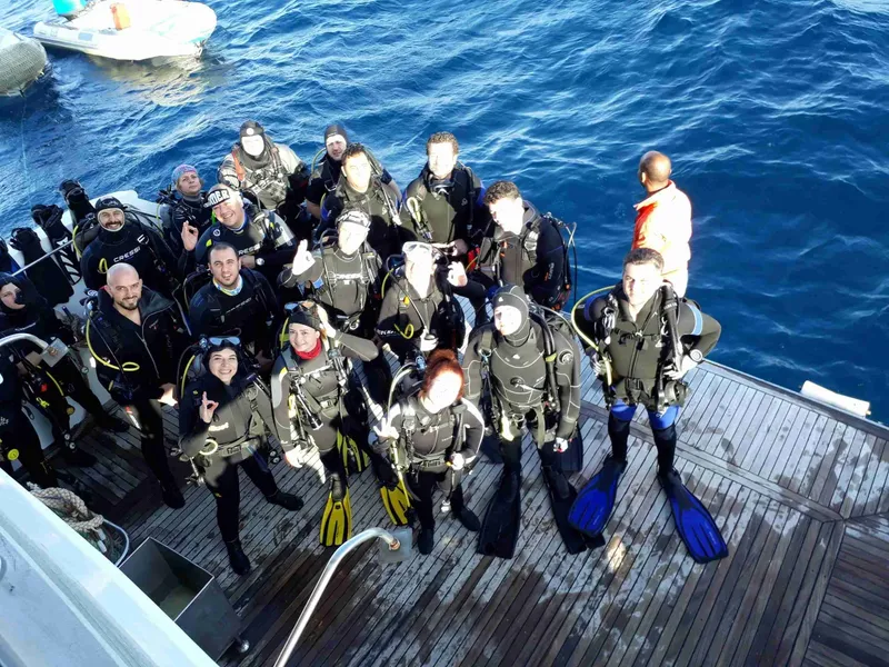 Groupe de plongeurs équipés sur le pont d'un bateau en mer
