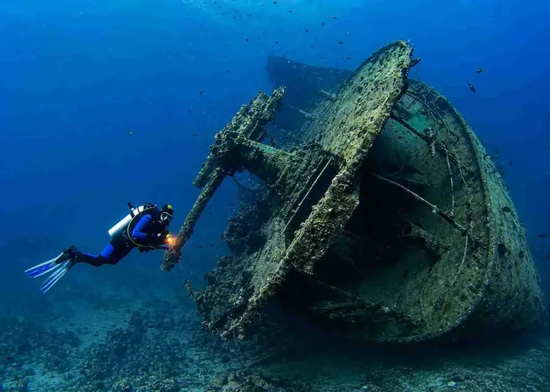 Plongeur explorant l'épave d'un bateau coulé en milieu marin