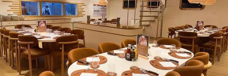 Salle à manger lumineuse avec tables dressées et décoration chaleureuse