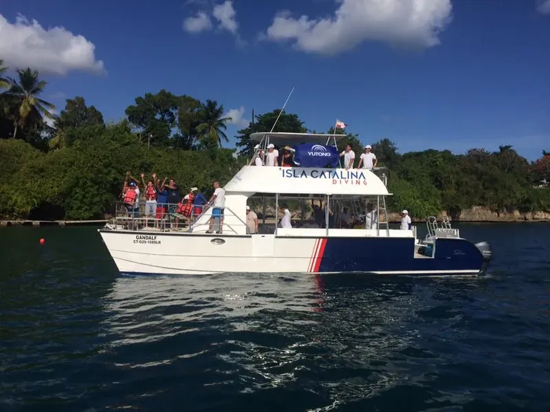 Bateau de plongée avec des passagers souriants et levant les mains