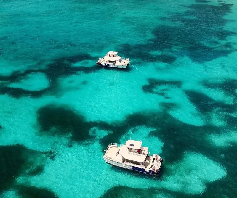Vue aérienne de deux bateaux de plongée sur une eau turquoise claire