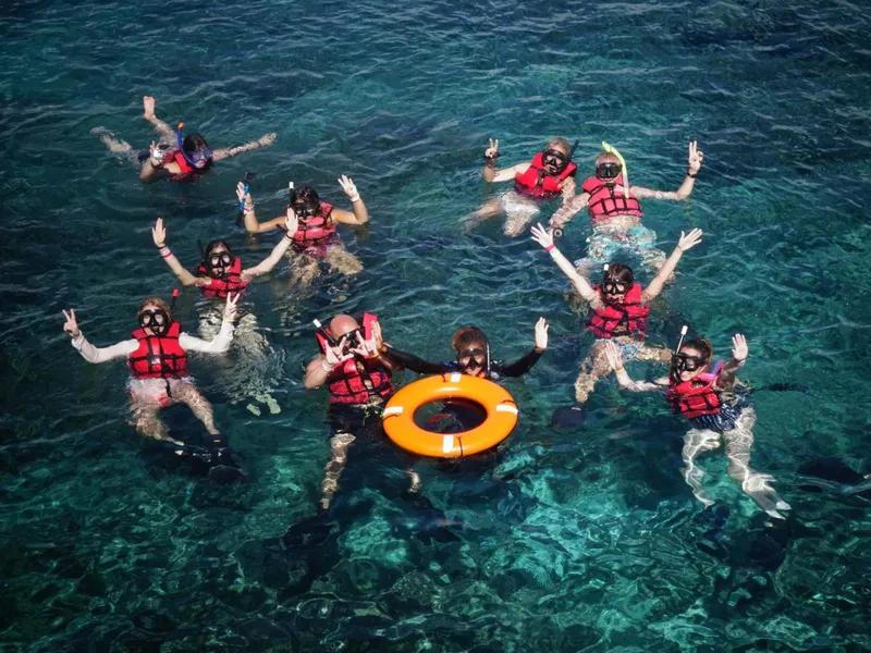 Groupe de personnes en gilets de sauvetage flottant dans l'eau