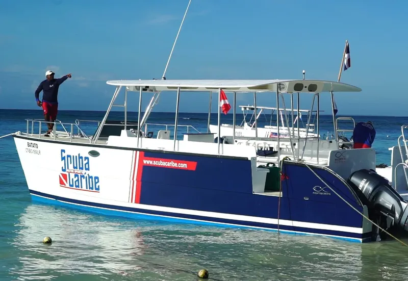 Bateau de plongée blanc et bleu amarré dans une eau turquoise claire