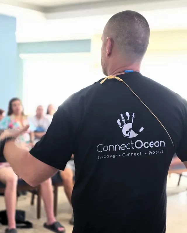 Un homme de dos présente un t-shirt avec un logo marin