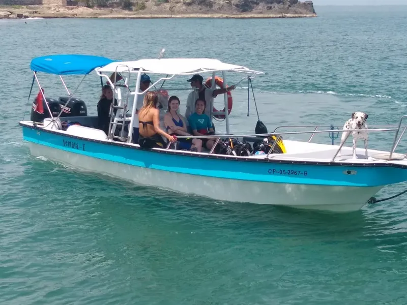Bateau de plongée turquoise en mer avec des passagers et équipement