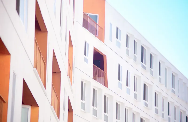 Facade d'immeuble moderne avec balcons et fenêtres répétitives