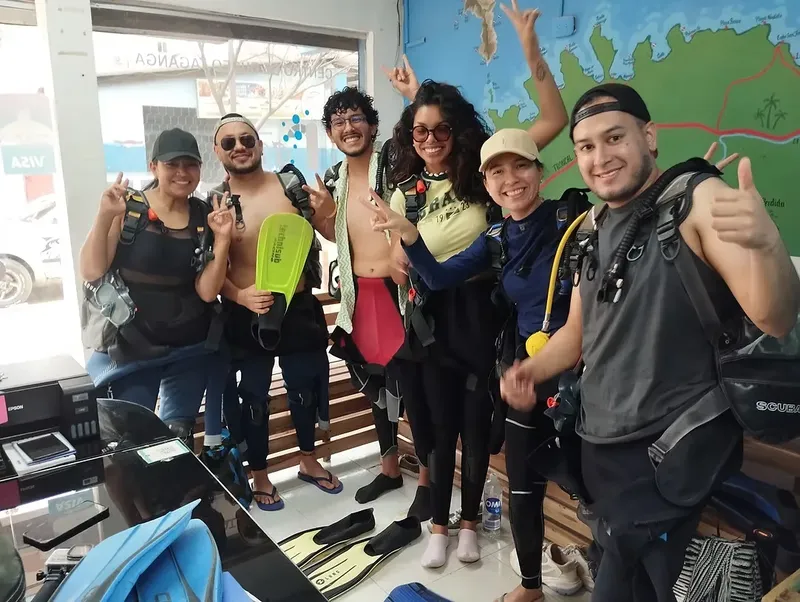Groupe de plongeurs souriants équipés dans un centre de plongée