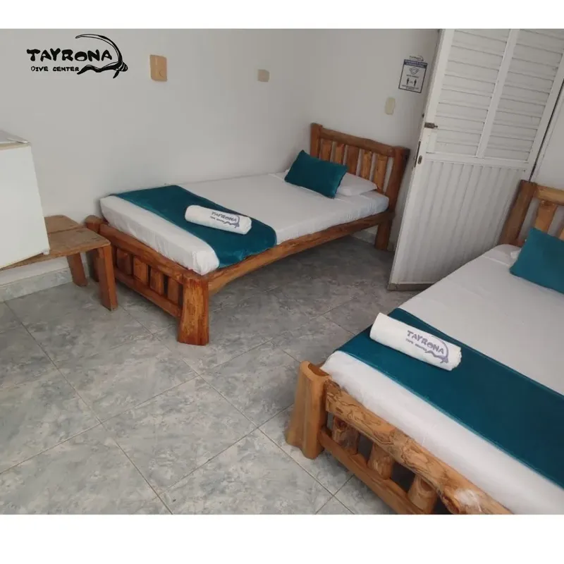 Chambre avec deux lits simples en bois et décoration turquoise