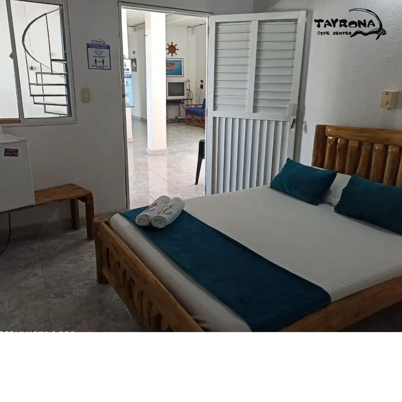 Chambre d'hôtel simple avec lit fait et décoration marine discrète