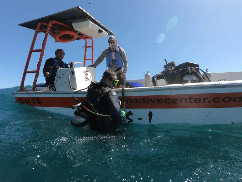 Plongeurs s'équipent sur un bateau blanc en mer, préparation plongée