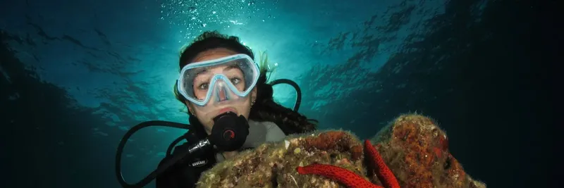 Plongeuse souriante avec masque et détendeur, exploration sous-marine