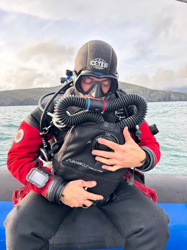 Plongeur vérifiant son équipement de plongée sur un bateau en mer