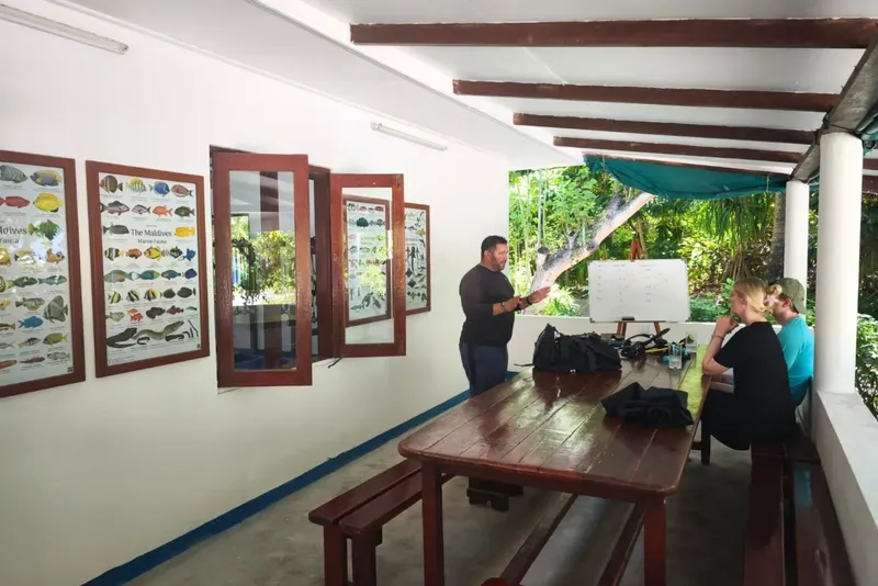 Un instructeur explique la plongée à des élèves dans une salle couverte