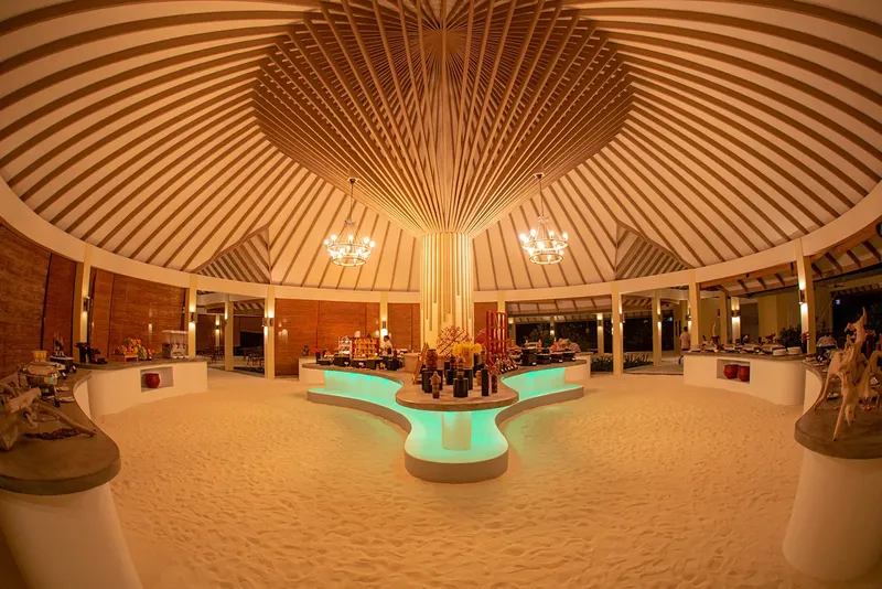 Intérieur d'un espace ouvert avec un sol sablonneux et un éclairage chaleureux