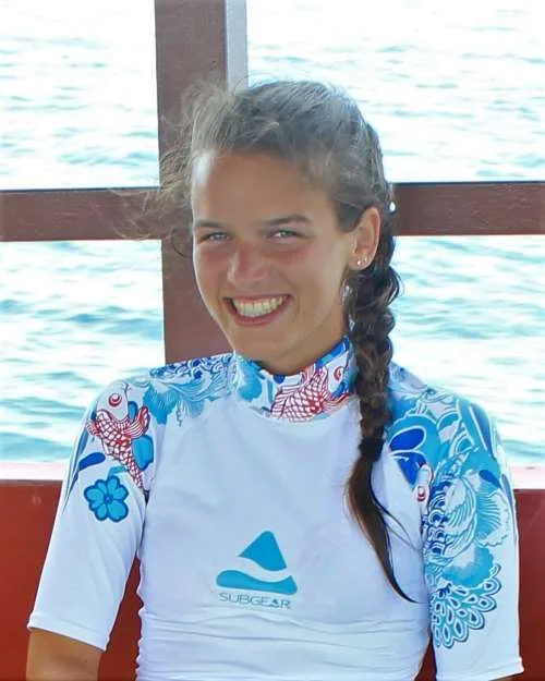 Jeune femme souriante portant un rashguard à motifs aquatiques