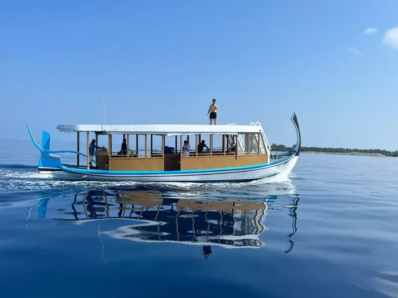 Bateau de plongée bleu et blanc navigue sur une mer calme