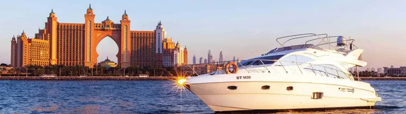 Yacht blanc naviguant devant un hôtel en forme d'arche dorée