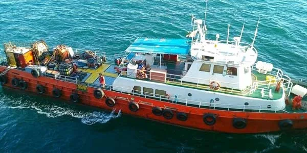 Bateau de plongée orange et blanc en mer avec des personnes à bord