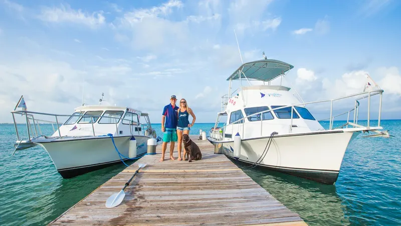 Deux personnes et un chien sur un ponton avec des bateaux