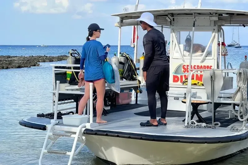 Deux plongeurs sur un bateau préparent leur matériel de plongée