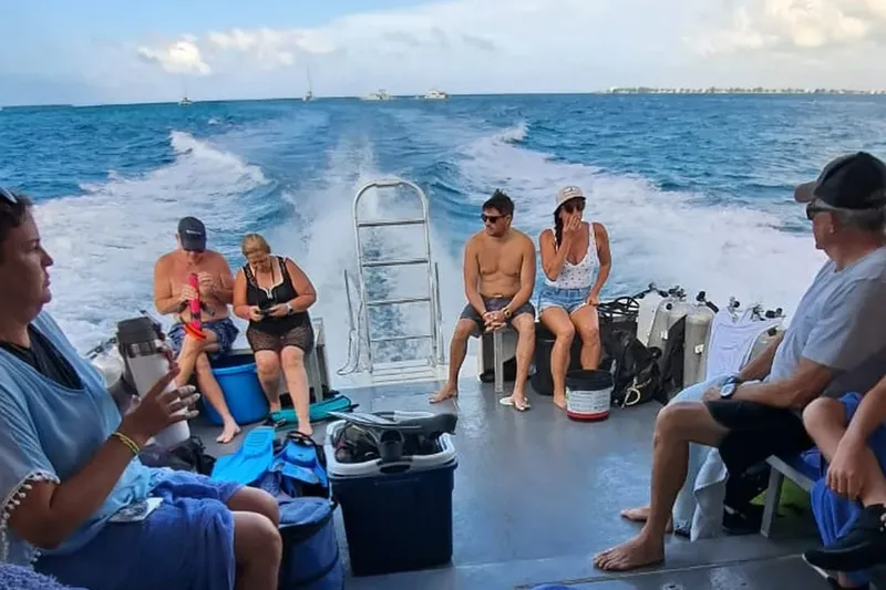 Groupe de plongeurs assis sur un bateau en direction d'un site