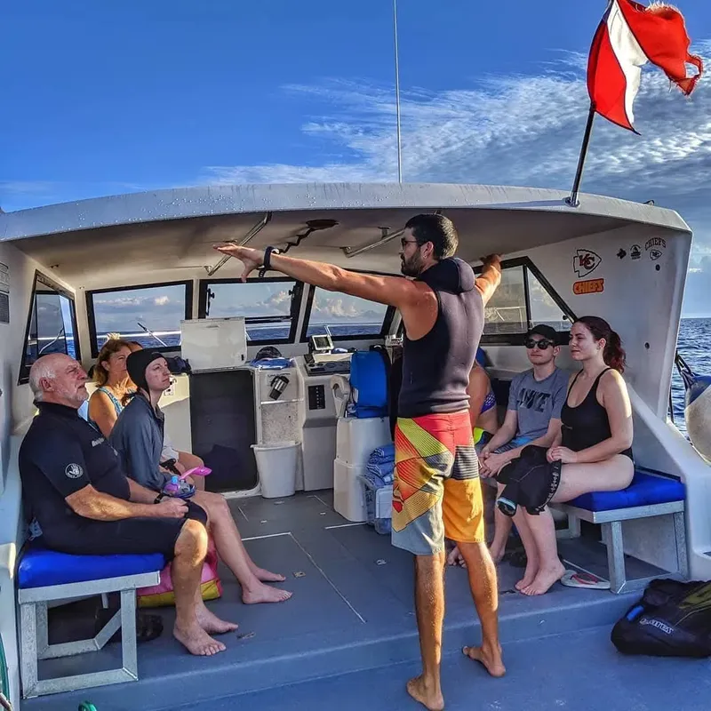 Groupe de plongeurs sur un bateau, un instructeur explique les consignes