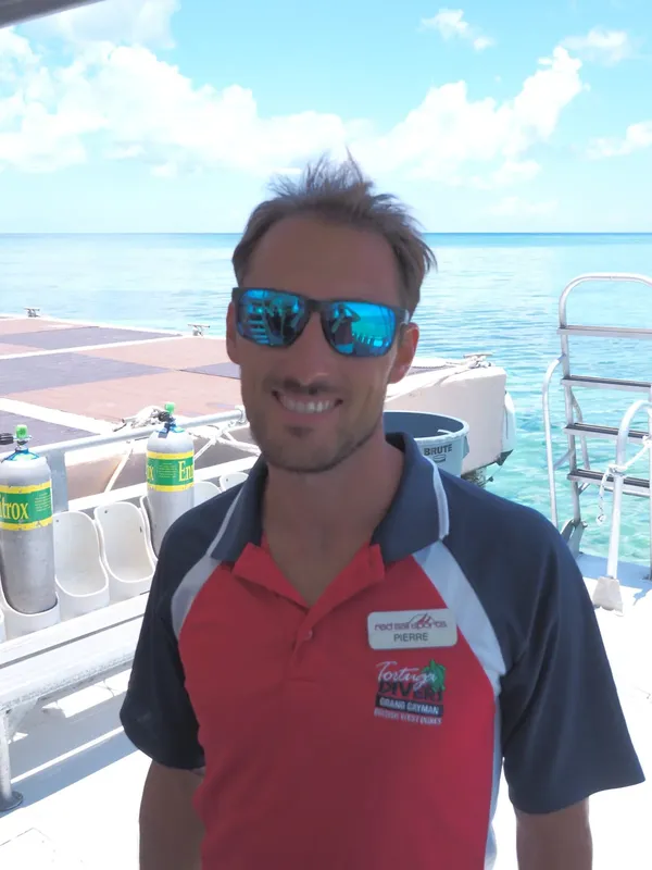Homme souriant avec lunettes de soleil sur un bateau de plongée