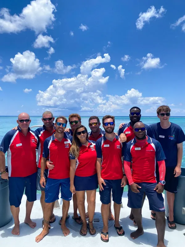 Groupe de personnes souriantes sur un bateau en mer turquoise
