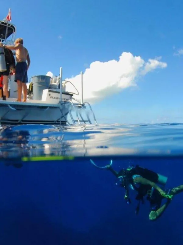 Plongeur explorant les profondeurs sous un bateau en mer bleue