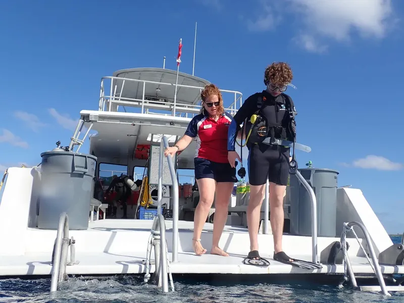 Deux plongeurs s'apprêtent à monter à bord d'un bateau de plongée