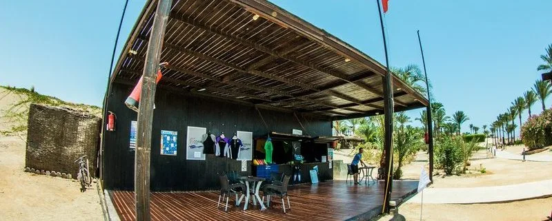 Façade d'un centre de plongée avec des combinaisons et des tables