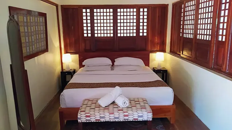 Chambre d'hôtel avec grand lit, décoration bois et ambiance chaleureuse