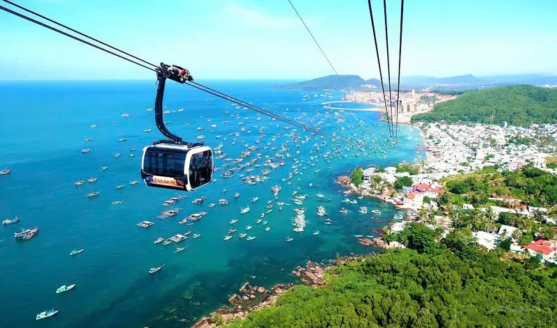 Vue aérienne d'une cabine de téléphérique au-dessus de bateaux et d'une ville côtière