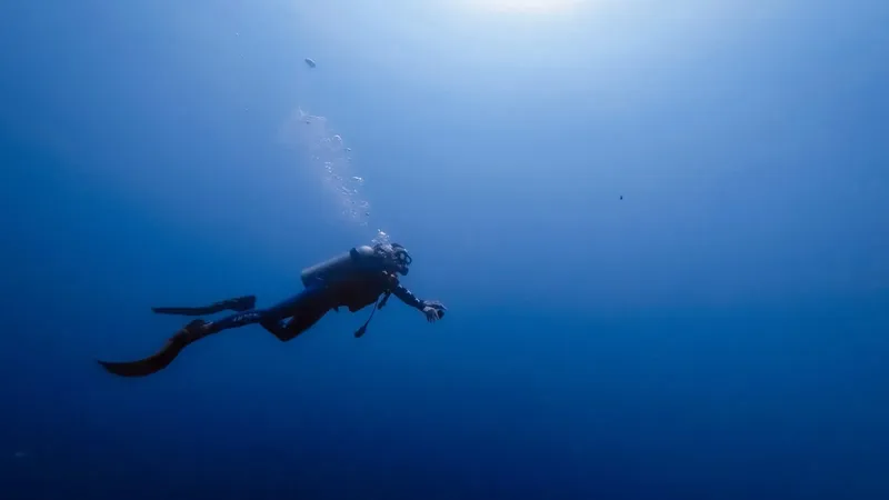 Plongeur en scaphandre explore les profondeurs bleues de l'océan