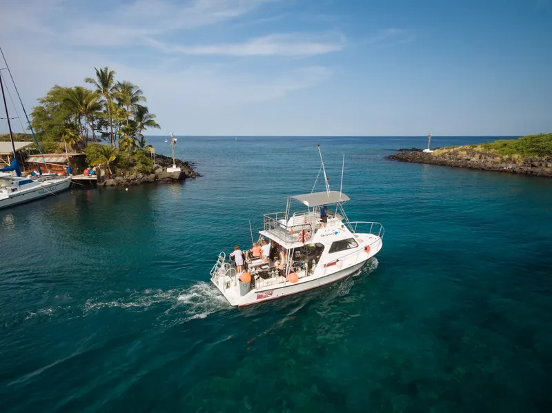 Bateau de plongée en mer avec des passagers, ciel bleu et eau turquoise
