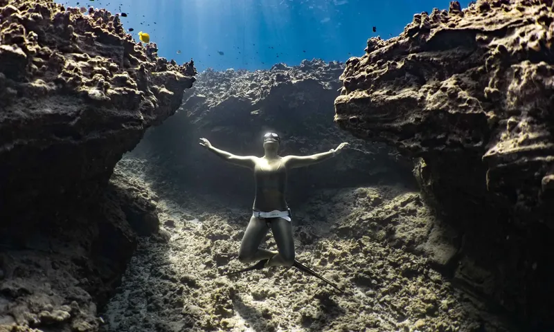 Apnea, une personne nageant les bras ouverts dans une grotte sous-marine