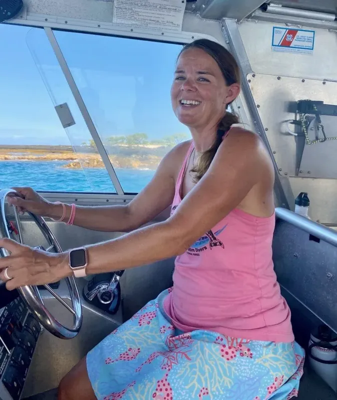 Femme souriante conduit un bateau de plaisance en mer ensoleillée