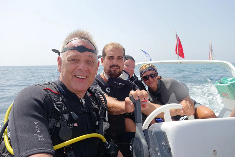 Plongée : groupe de personnes souriantes à bord d'un bateau rapide