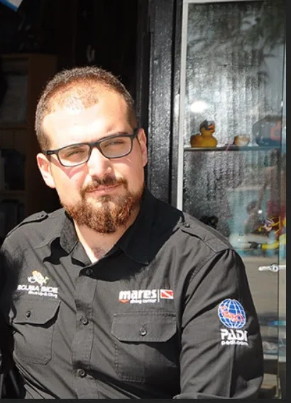 Homme portant une chemise avec des logos de marques de plongée