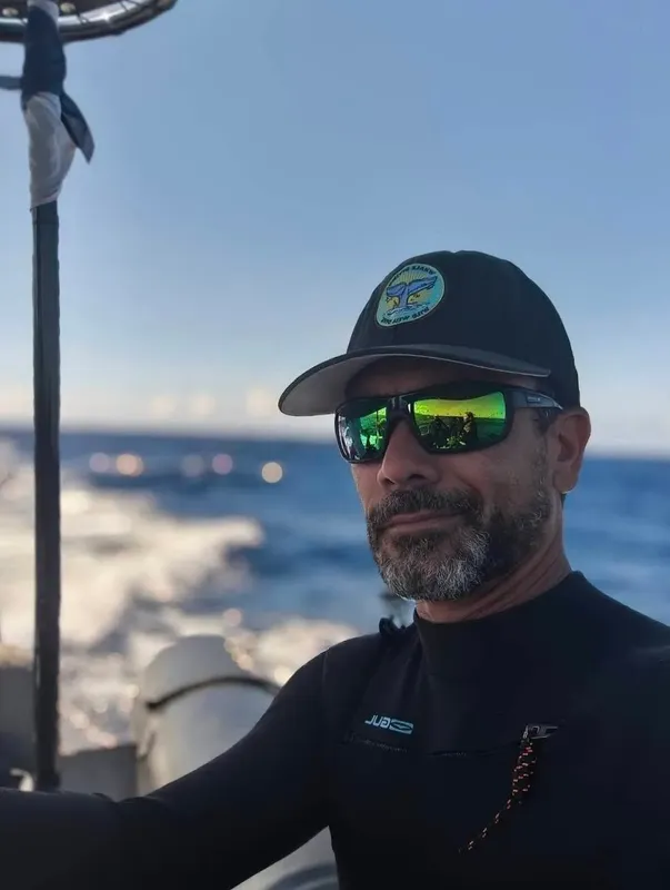 Portrait d'un homme barbu portant des lunettes de soleil sur un bateau