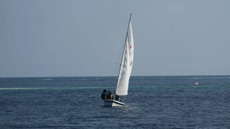 Voilier blanc avec quelques personnes à bord sur mer calme
