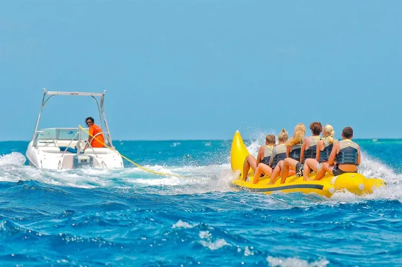 Personnes sur une bouée tractée par un bateau rapide en mer