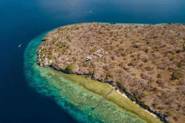 Vue aérienne d'une île tropicale avec récif corallien et bateaux