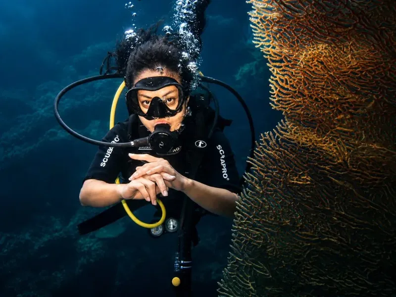 Plongeur en pleine immersion, regardant vers l'avant, corail à droite