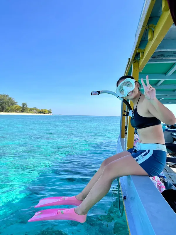 Jeune femme avec masque et palmes sur un bateau en mer