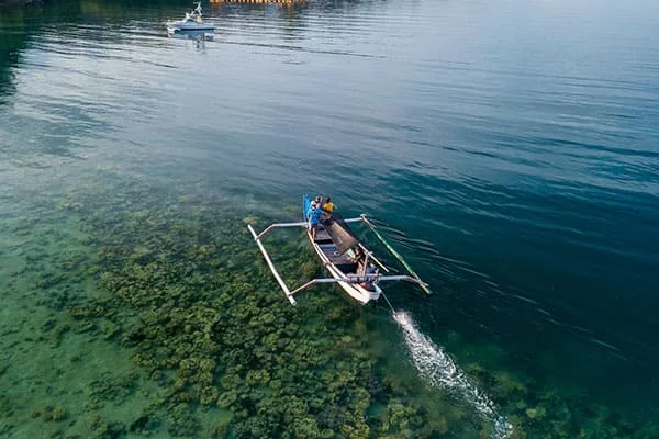Vue aérienne d'un bateau traditionnel avec des personnes à bord sur mer