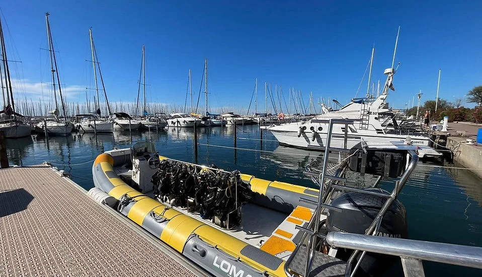 Bateau de plongée amarré dans un port ensoleillé avec équipement