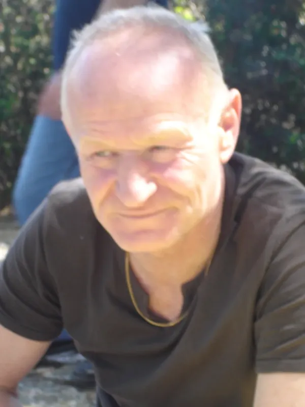 Portrait d'un homme souriant, regardant la caméra, en extérieur