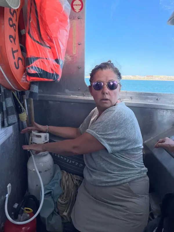 Femme portant des lunettes de soleil à bord d'un bateau de plongée